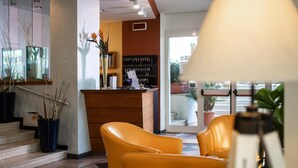 A hotel lobby with a reception desk, check-in counter, and seating area. - Amadei Hotel Figaro & Apartments (Pesaro)