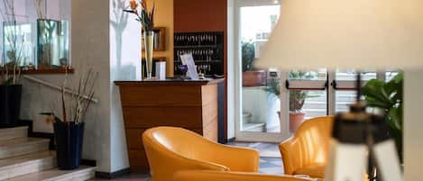 A hotel lobby with a reception desk, check-in counter, and seating area.