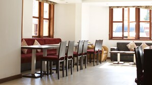 Un comedor espacioso con vigas de madera, una mesa larga y sillas.