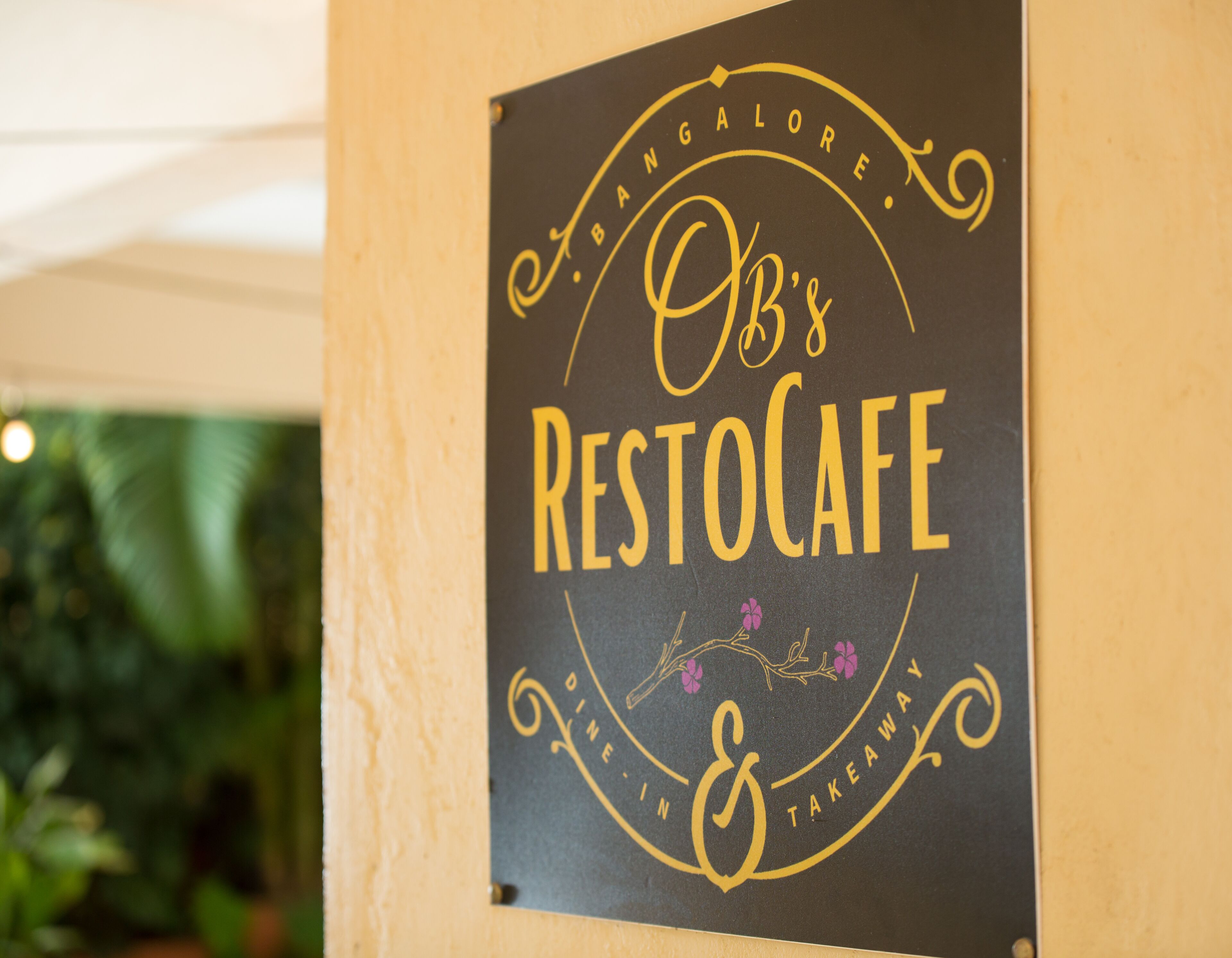 A sign for 'OB's RestoCafe' with a circular design and decorative elements.