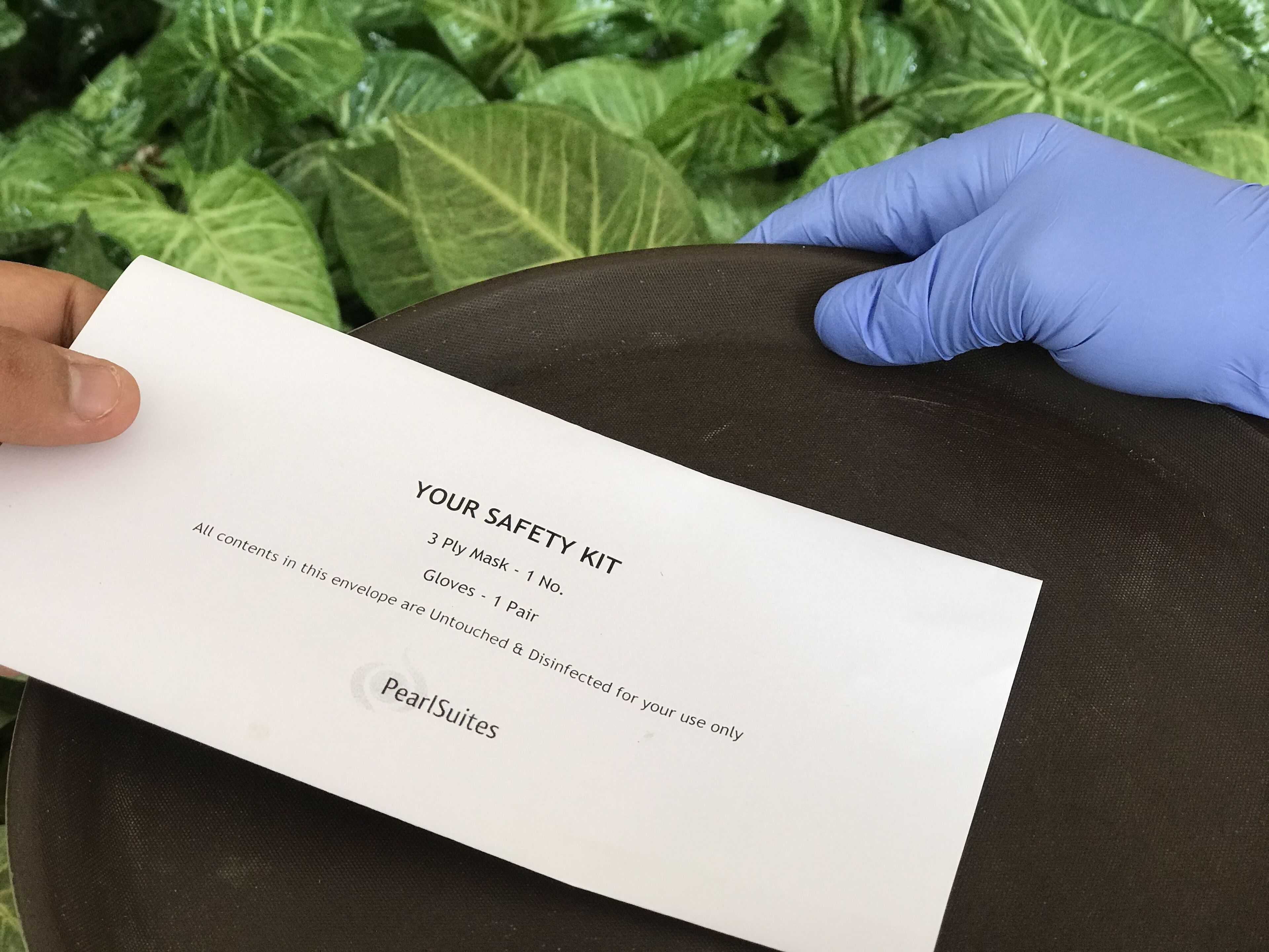 A person holding a white card with safety kit details.