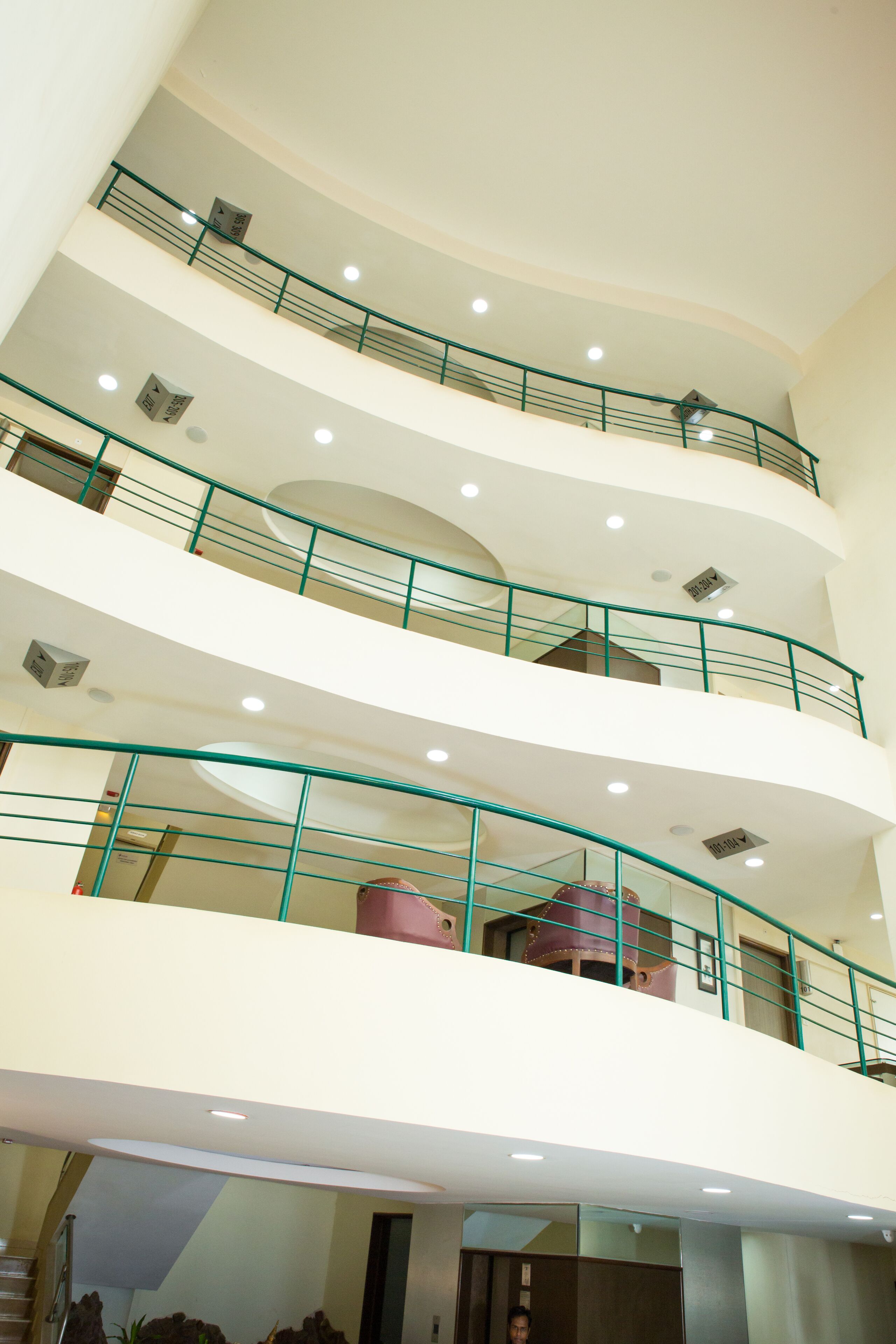 A multi-level interior with balconies, railings, and a staircase.