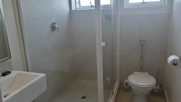 Un baño con ducha, inodoro y lavabo.