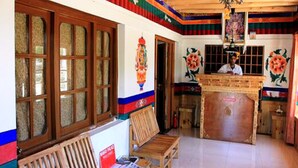 Un edificio tradicional con bancos de madera, una mesa de recepción y coloridas decoraciones en las paredes.