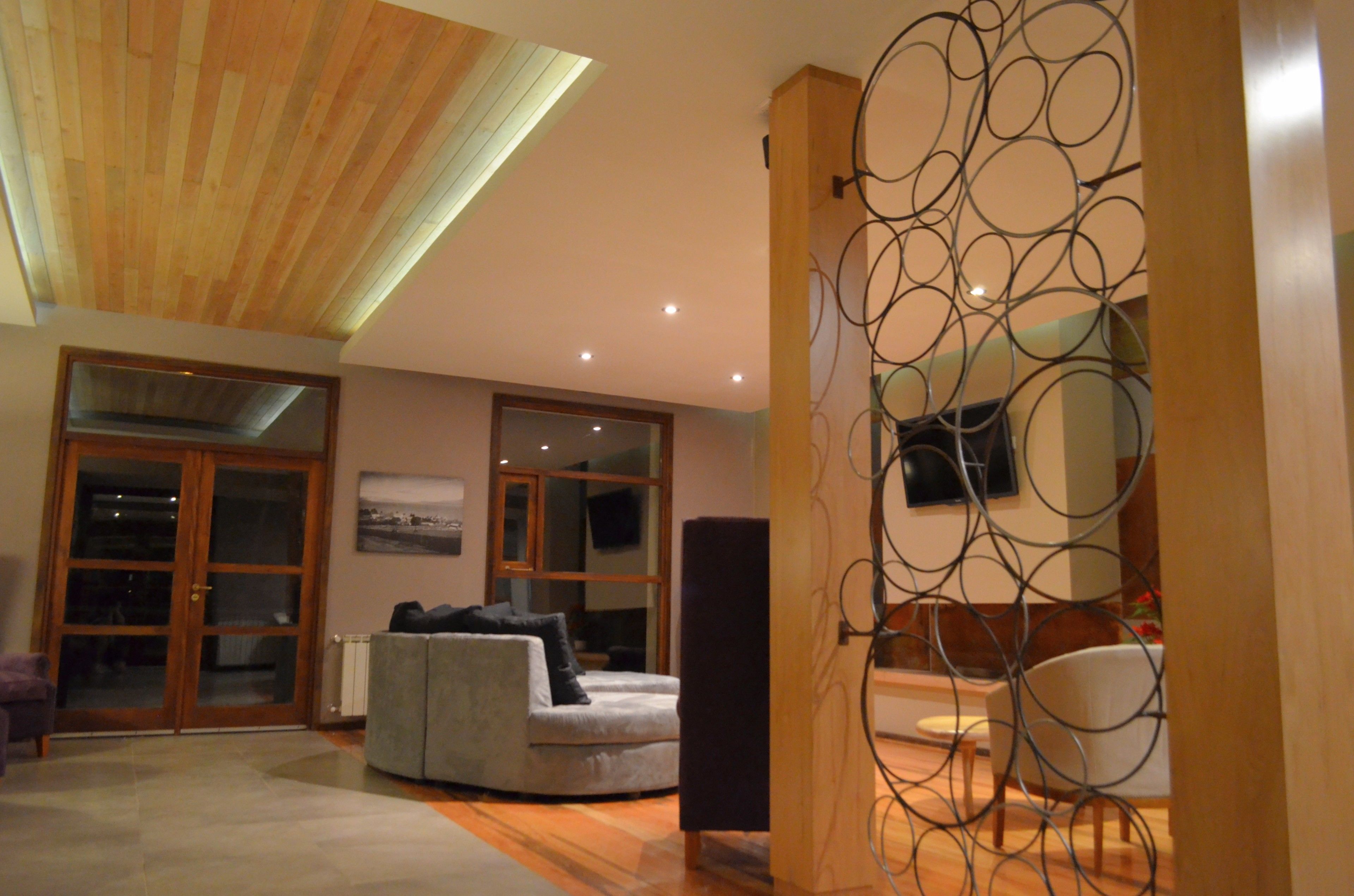 A spacious living area with a high ceiling, a large window, and a modern fireplace.
