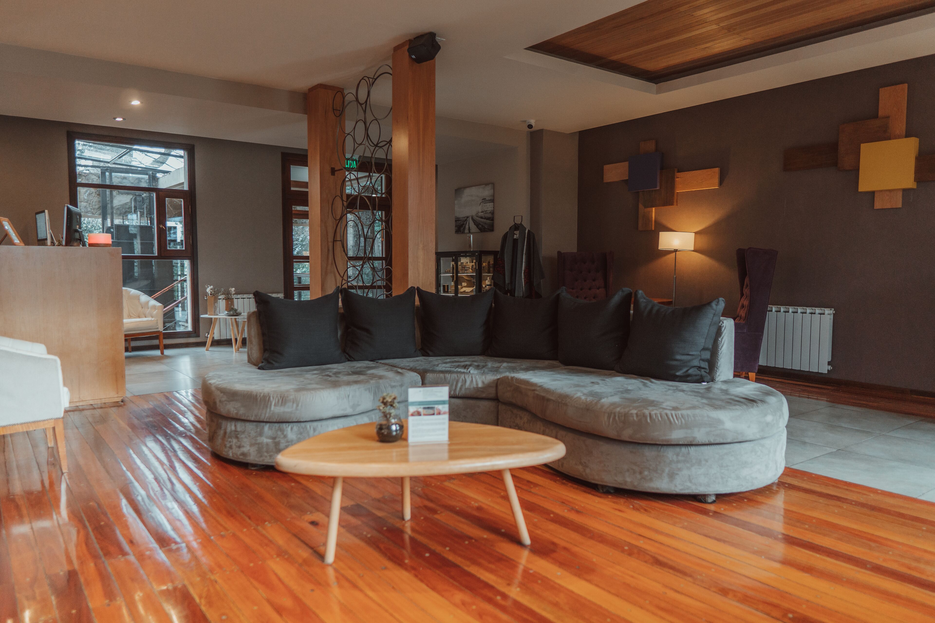 A modern living room with a sectional sofa, a round coffee table, and a large window providing natural light.