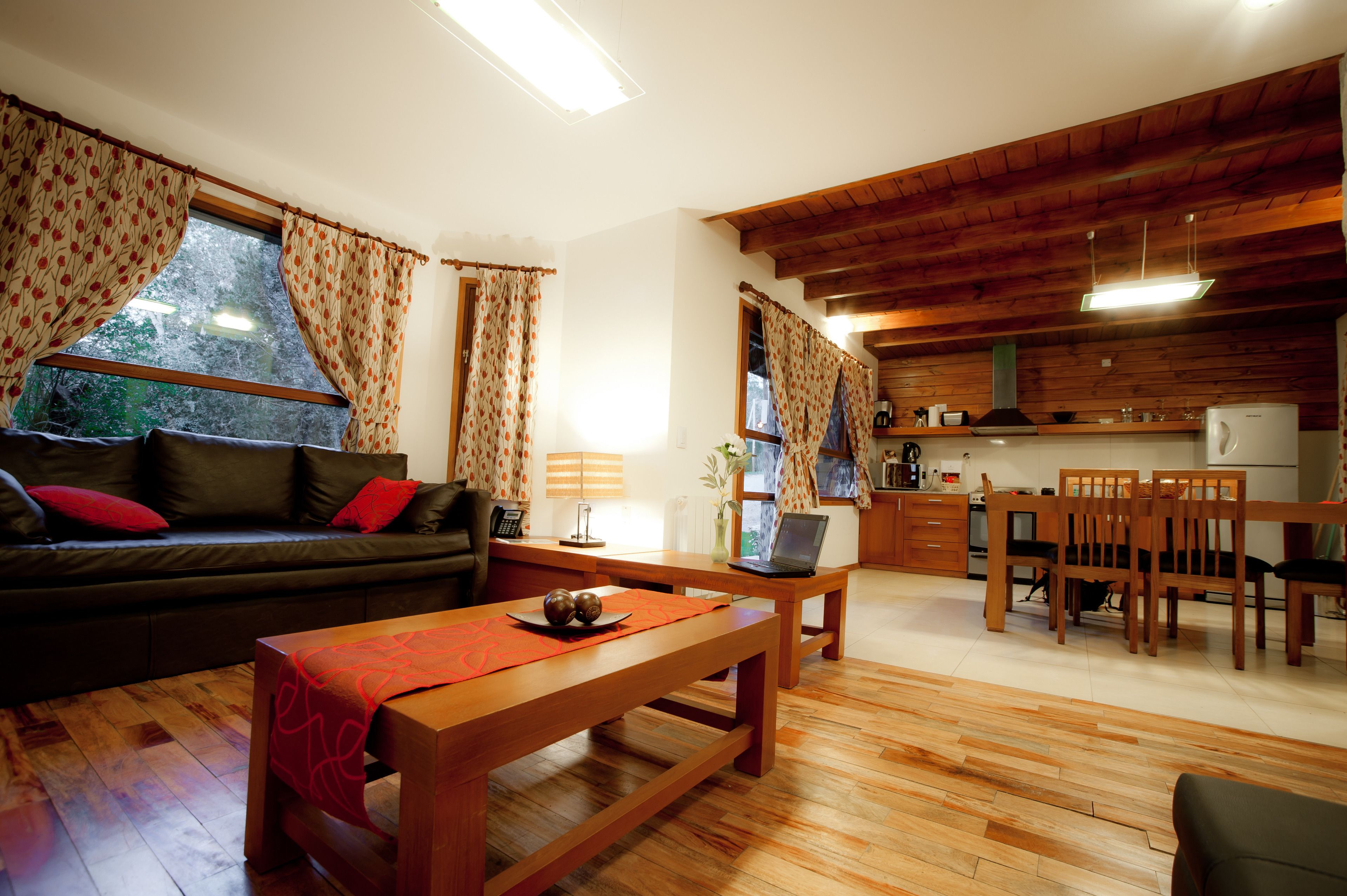 Un salon chaleureux avec un canapé, une table basse et un coin repas agrémenté de meubles en bois.