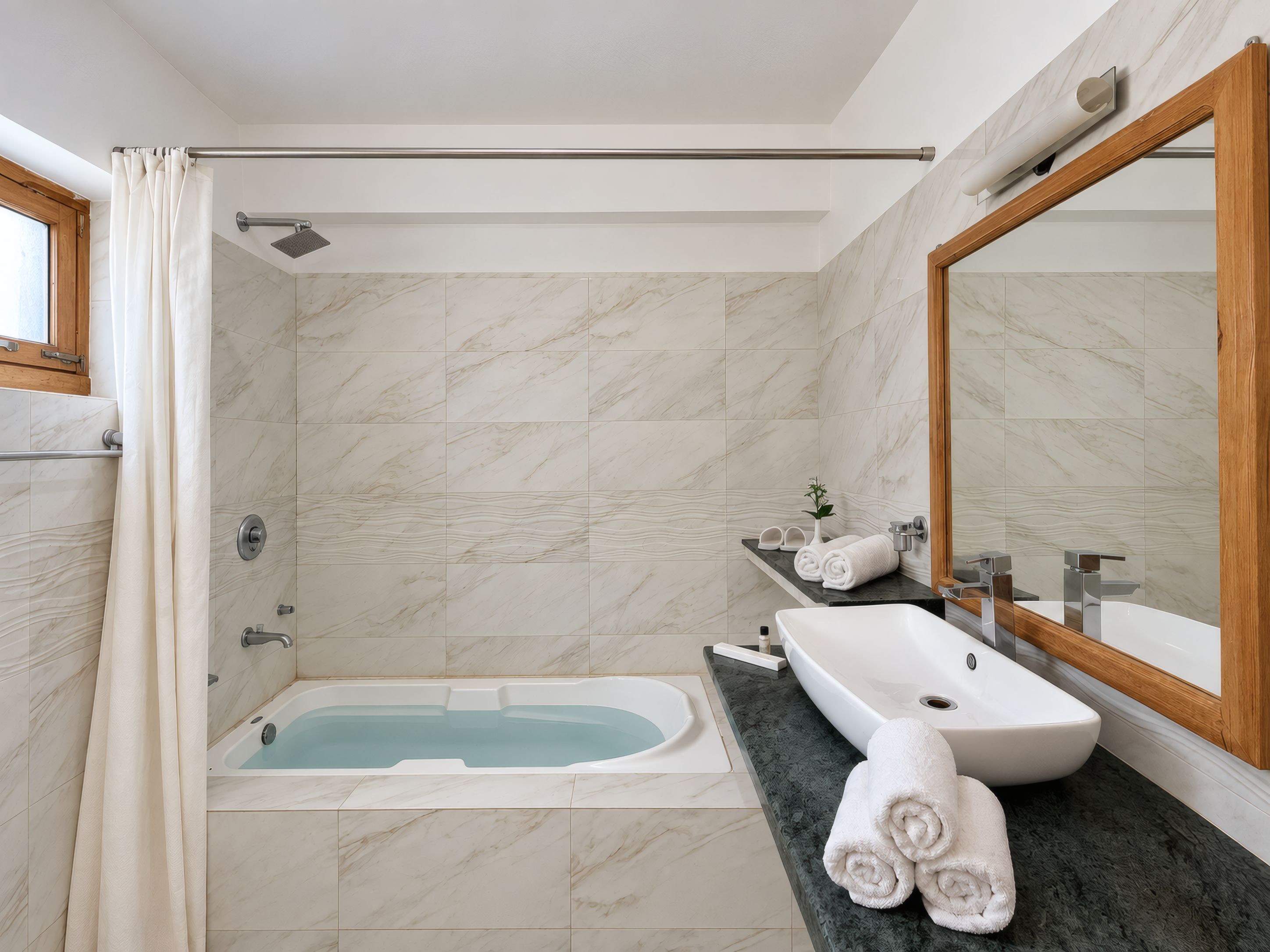 A modern bathroom with a bathtub, a sink, and a large mirror.
