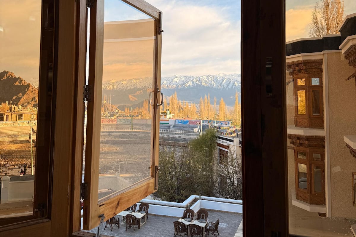 A room with a large window overlooking a mountainous landscape with a clear sky.