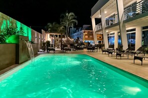 Een buitenzwembad, ligstoelen bij het zwembad