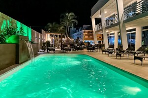 Una piscina al aire libre, sillones reclinables de piscina