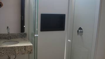A bathroom with a glass-enclosed shower, a sink with a marble countertop, and a toilet.