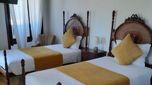 A hotel room with two wooden beds, white bedding, and a wooden floor. - Hotel Ribamar (Nazaré)