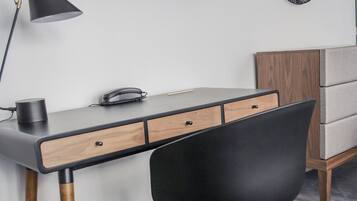 Un espacio de oficina moderno con un escritorio, una silla y un televisor montado en la pared.
