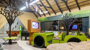A play area with a pool table, foosball table, and a large rock. - Waterberg Game Park (Vaalwater)