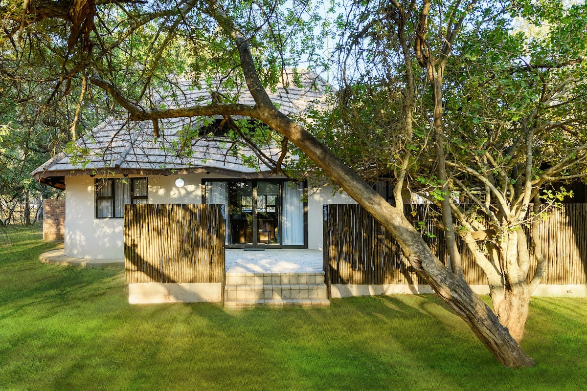 A house with a tiled roof, a front porch, and a wooden fence.