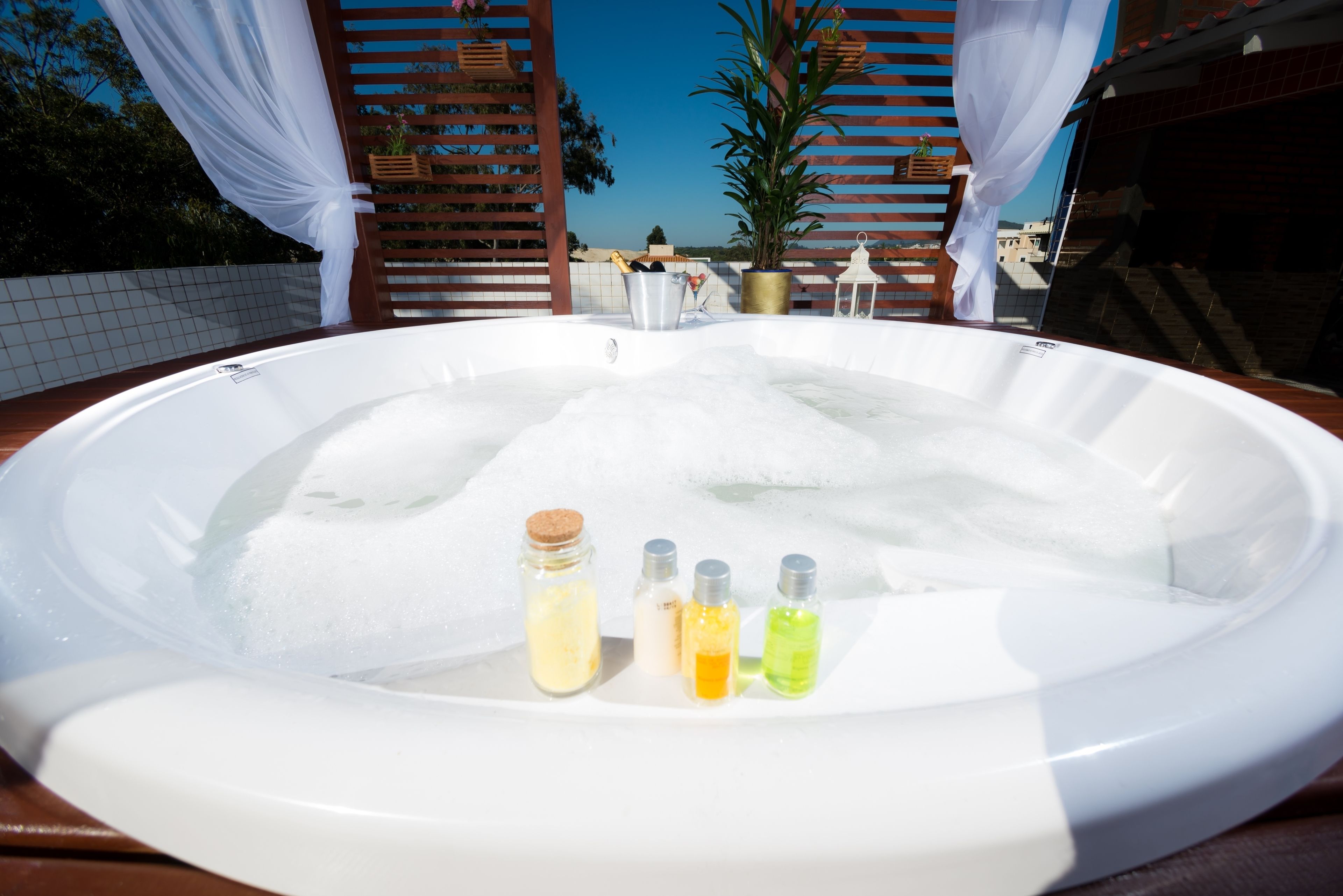 A hot tub with four bottles of bath products.