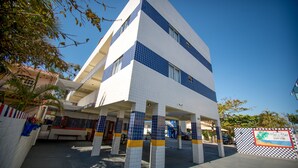 A multi-story building with a tiled facade, a covered entrance area, and a checkered signboard. - Mar e Mar Florianópolis (Florianópolis)