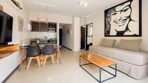 A modern living room with a sofa, a coffee table, and a dining area with chairs and a kitchen in the background. - Feel Buenos Aires (Buenos Aires)