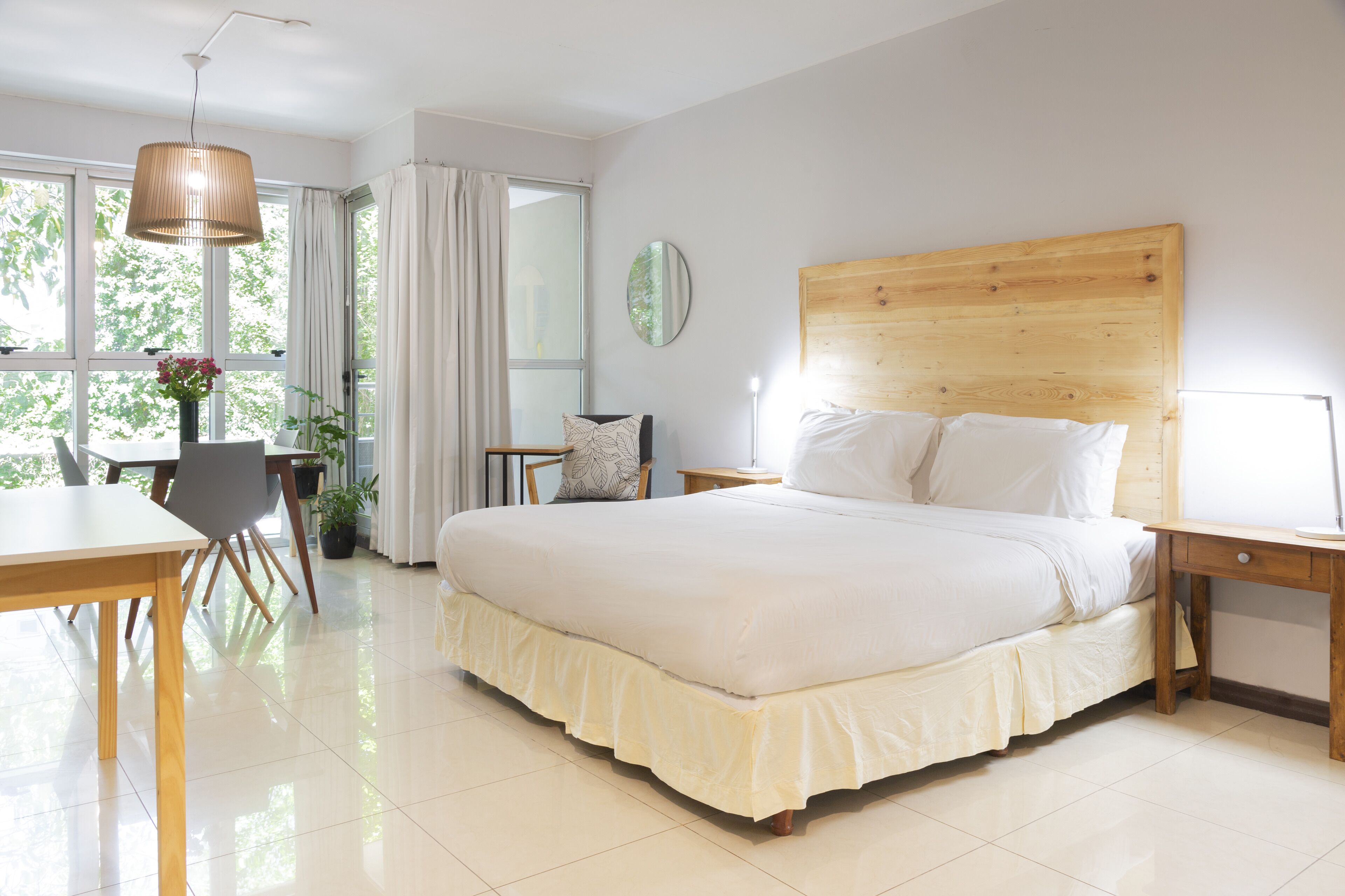Ampia camera da letto con un letto grande, una testiera in legno, comodini, una scrivania e una sedia.