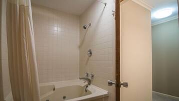 Een badkamer met een bad, een douche en een toilet.