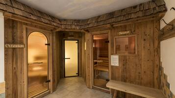 Ein Holzinterieur mit Sauna- und Vitariumräumen, einer Sitzbank und einer Holzbalkendecke.