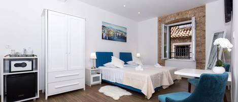 A modern bedroom with a bed, bedside tables, a desk, and a wardrobe.