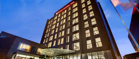 Un moderno edificio de hotel con un letrero llamativo que dice "Hilton Garden Inn".