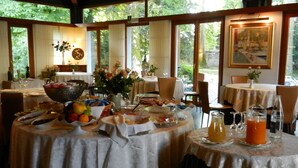 Zona de dinar amb taules preparades per esmorzar, amb diversos plats i begudes.