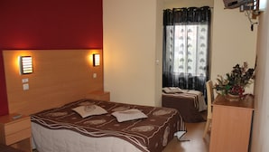 A hotel room with a large bed, bedside tables, a desk, and a window with curtains. - Guest House Estrela (Porto)