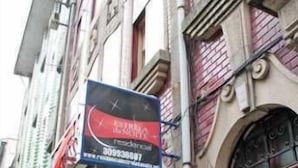 A building with a large signboard, arched windows, and a wooden door. - Guest House Estrela (Porto)