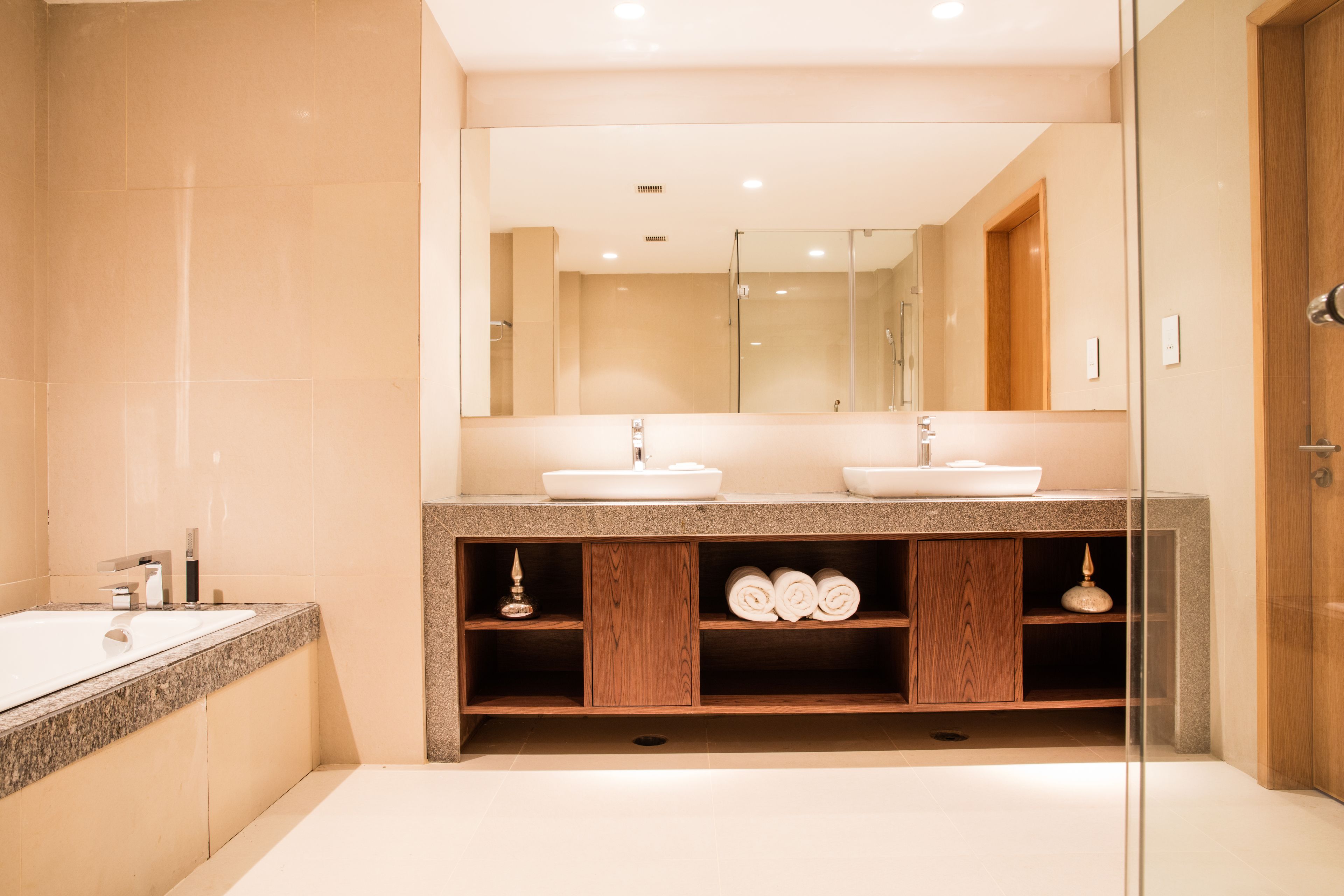 Un baño moderno con tocador doble, un espejo grande y cabina de ducha de vidrio.