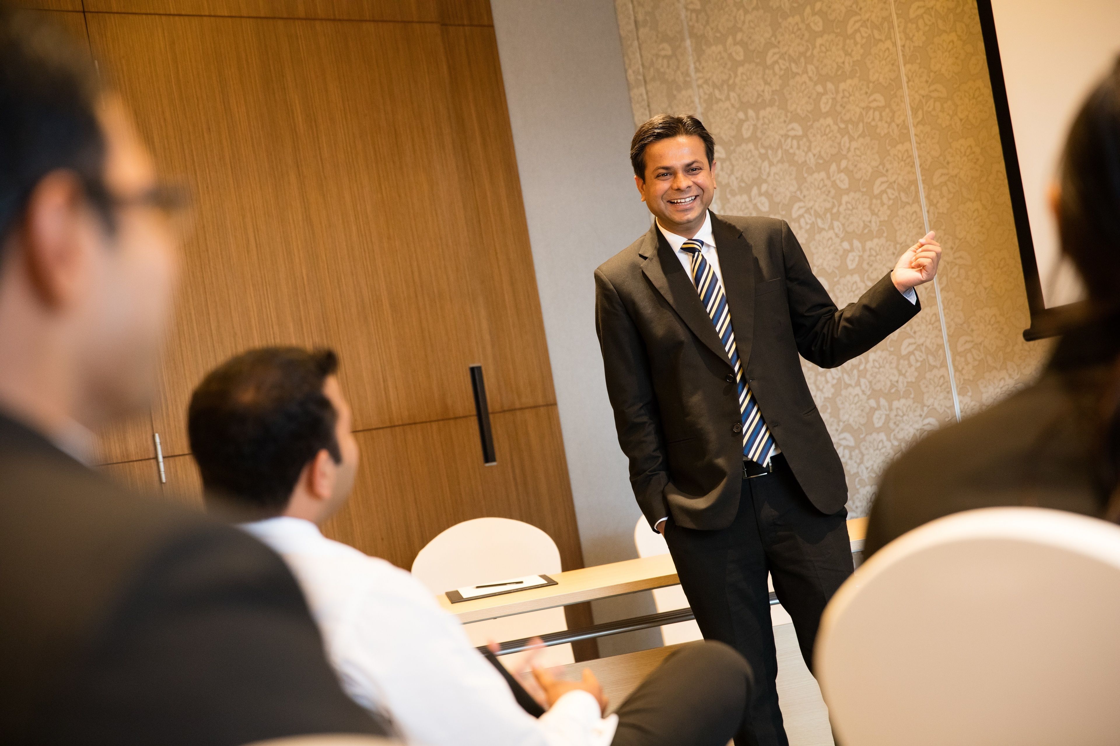 A conference room with a speaker presenting to an audience.