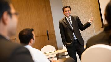 A conference room with a speaker presenting to an audience.
