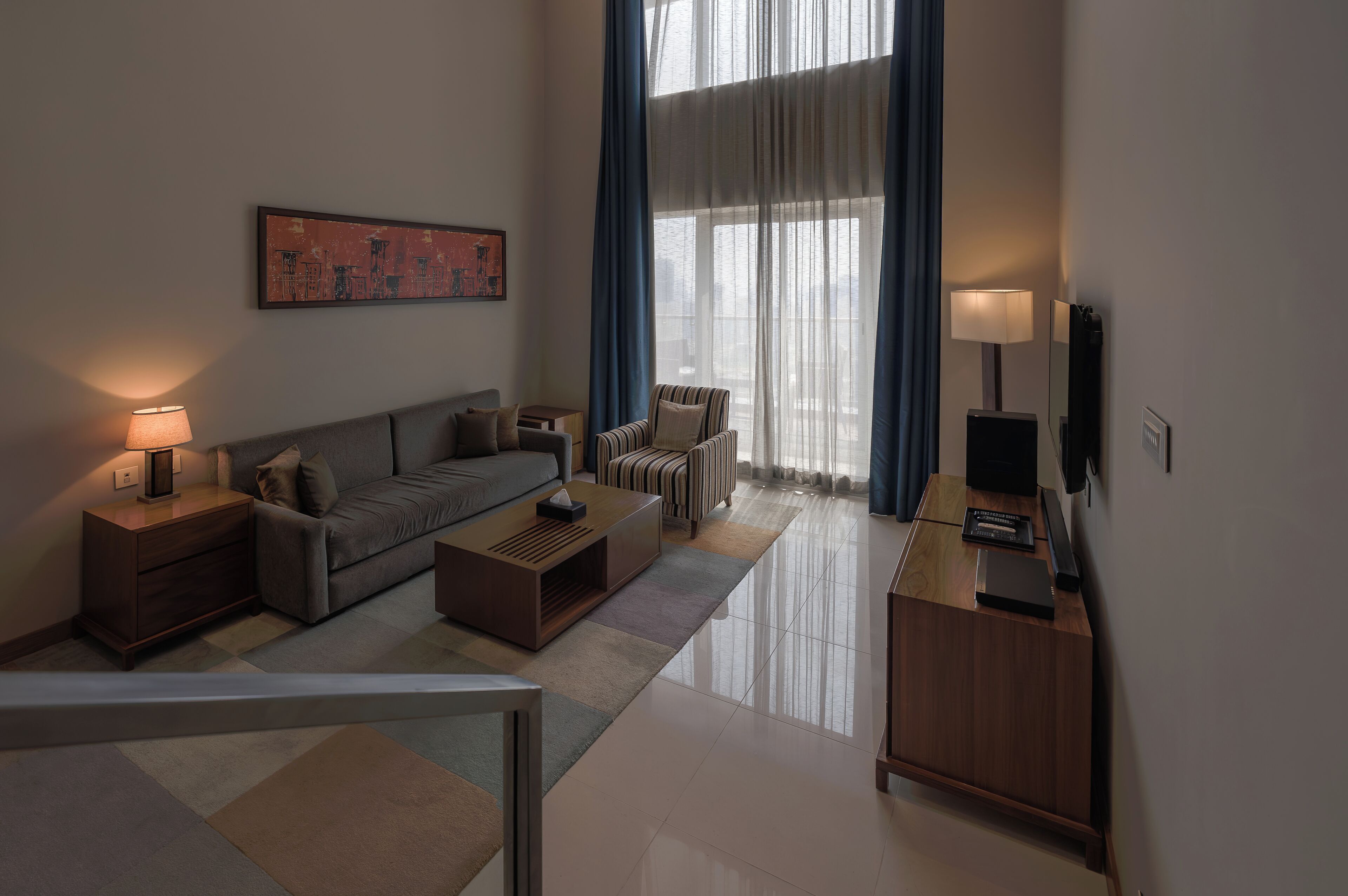 A modern living room with a sofa, coffee table, and a TV on a wooden cabinet.