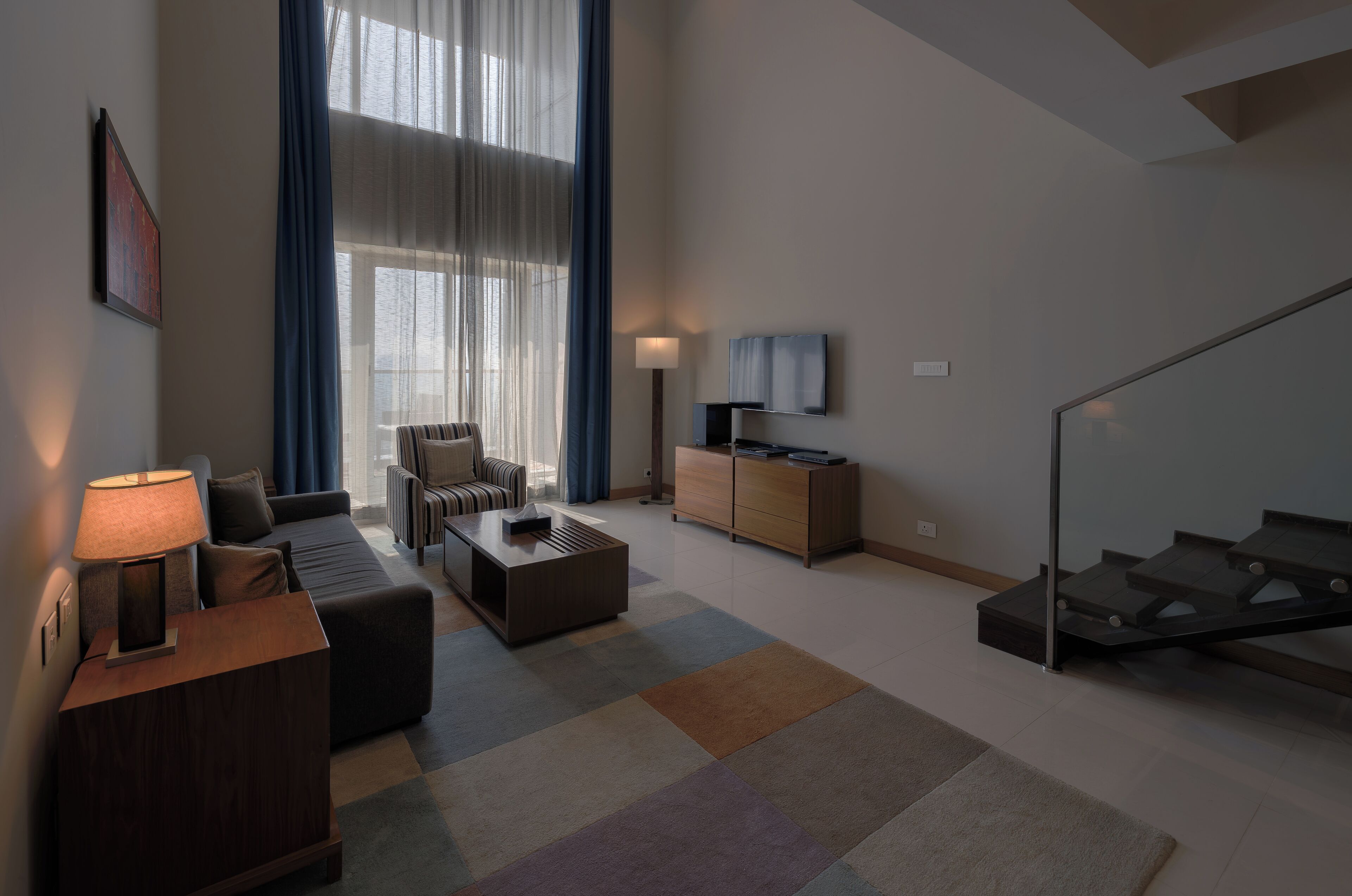 A modern living room with a sofa, coffee table, and a TV on a stand.