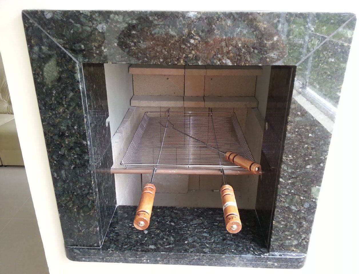 Cocina con una parrilla empotrada y pomos de madera.