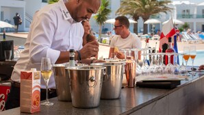 Un espace bar avec plusieurs seaux en métal, une bouteille et des verres sur un comptoir.