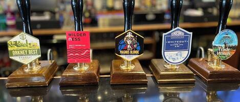 A bar with five beer taps, each with a unique label.