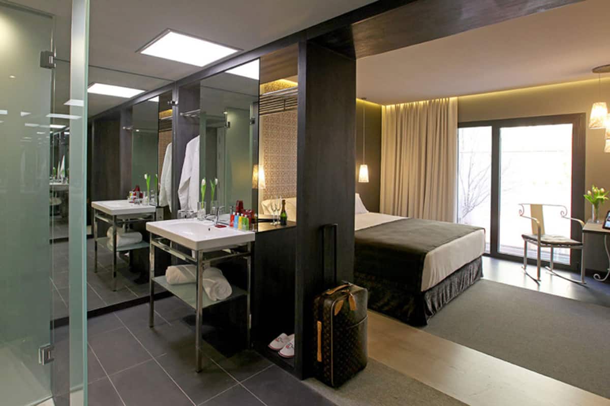 Una habitación de hotel moderna con cama, mesita de noche y escritorio con silla.