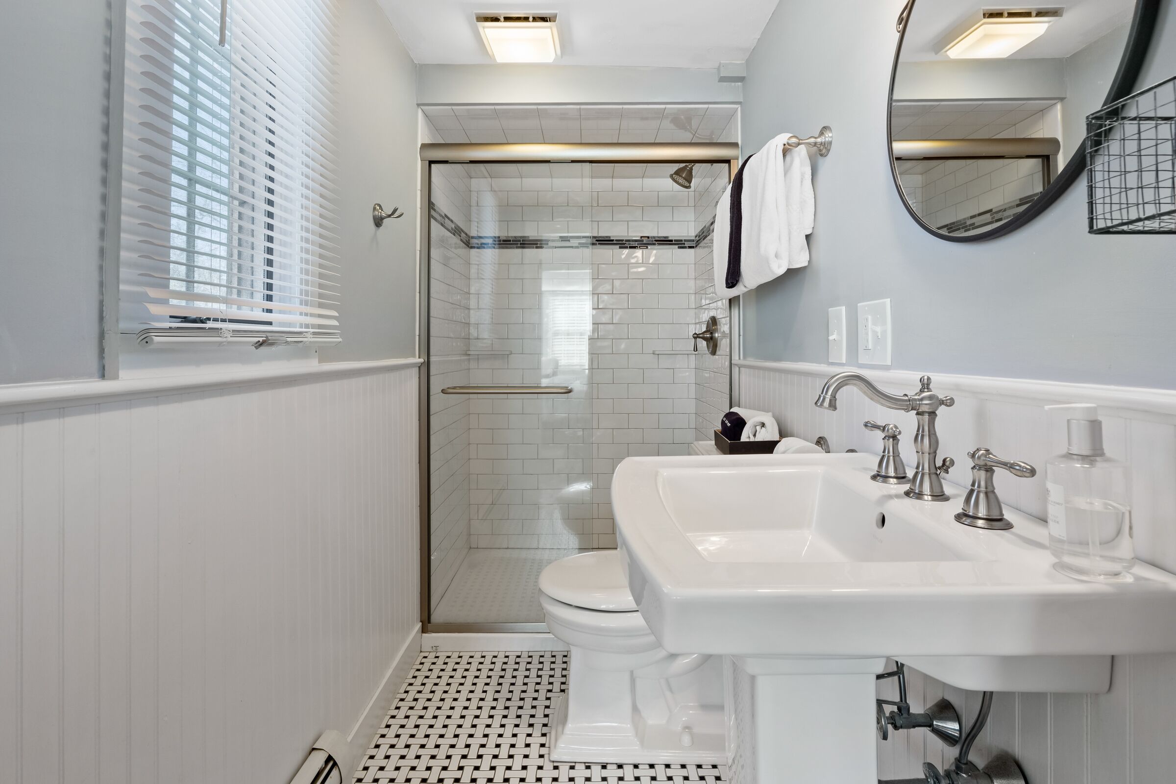 A modern bathroom with a shower, toilet, and sink.