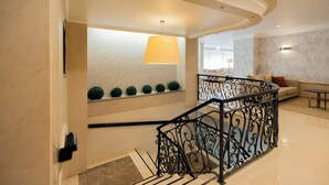 A modern interior with a staircase, a sofa, and a table.