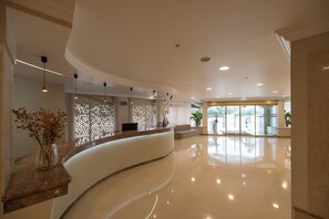 A modern hotel lobby with a curved reception desk, a seating area, and a large glass door entrance. - Avenida de Fátima (Ourem)