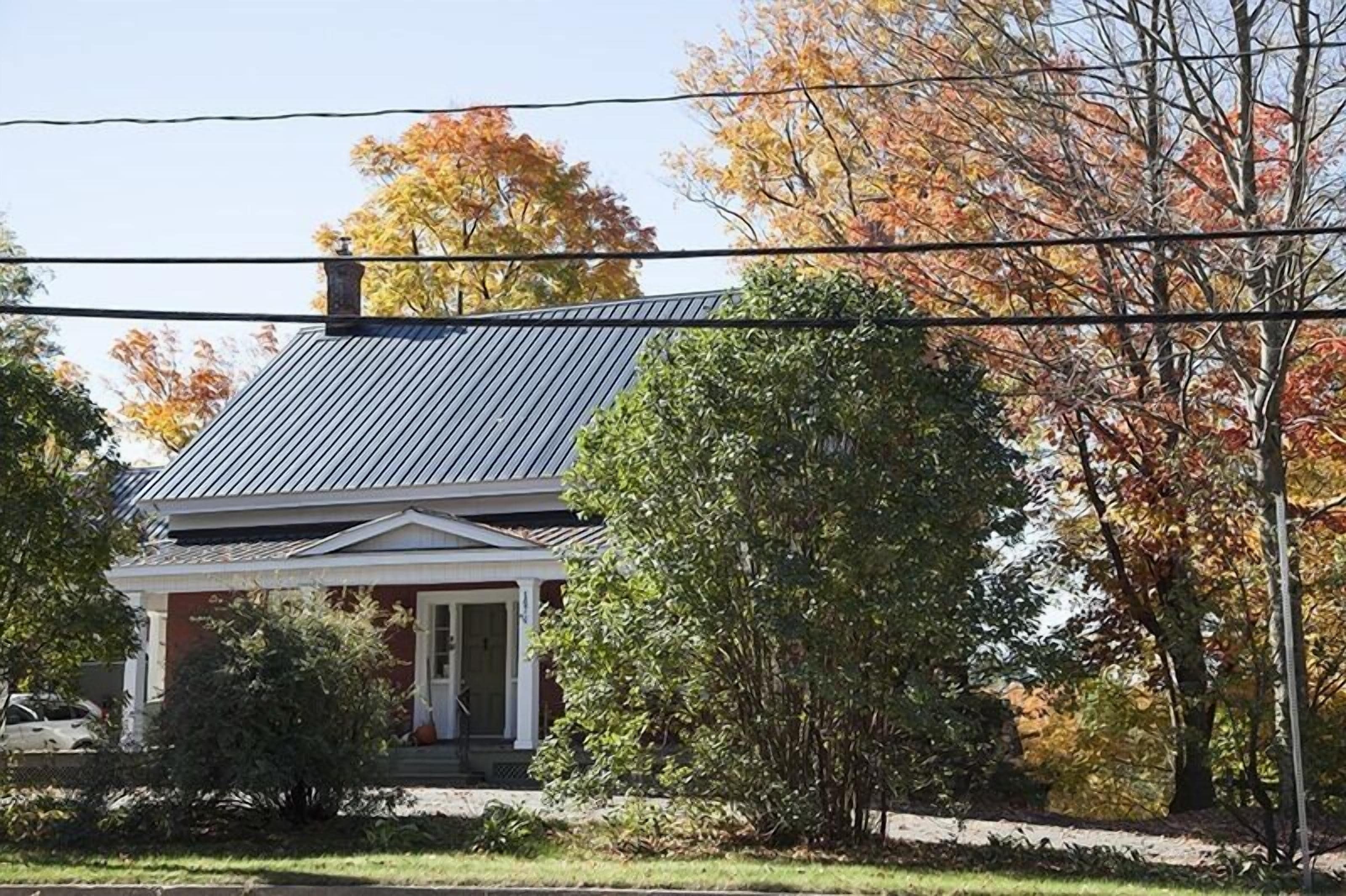 A two-story house with a dark roof and a front porch.