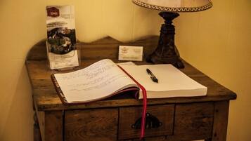 A wooden desk with a lamp, a notebook, and a brochure.