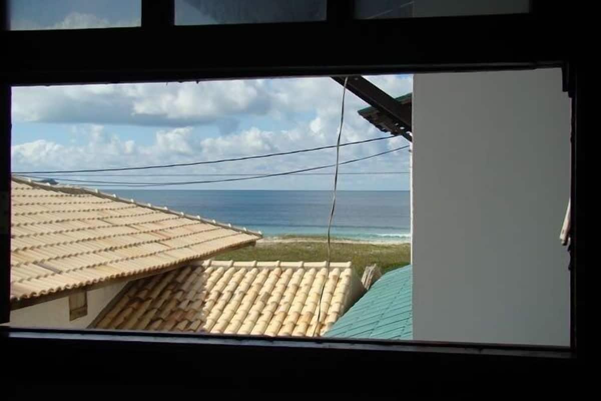 Blick auf einen Strand mit einem Ziegeldach und blauem Himmel.