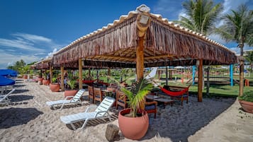 Am Strand, weißer Sandstrand, Liegestühle, Sonnenschirme