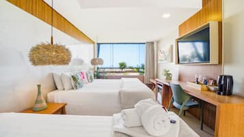 A hotel room with two beds, a desk, a TV, and a balcony with a view.