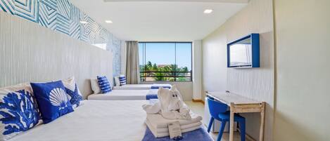 A hotel room with two beds, a desk, a chair, a TV, and a view of greenery outside.