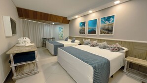 Habitación de hotel con dos camas, un escritorio y una silla. Hay tres cuadros en la pared.
